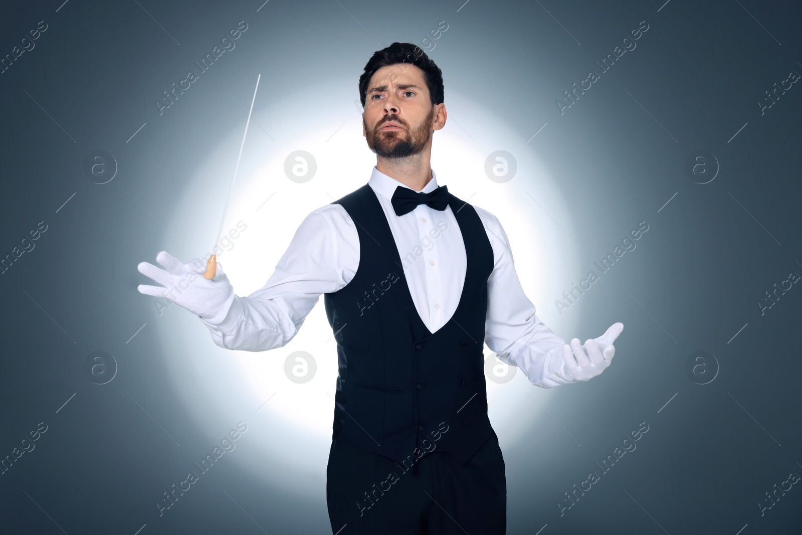 Photo of Professional conductor with baton on grey background