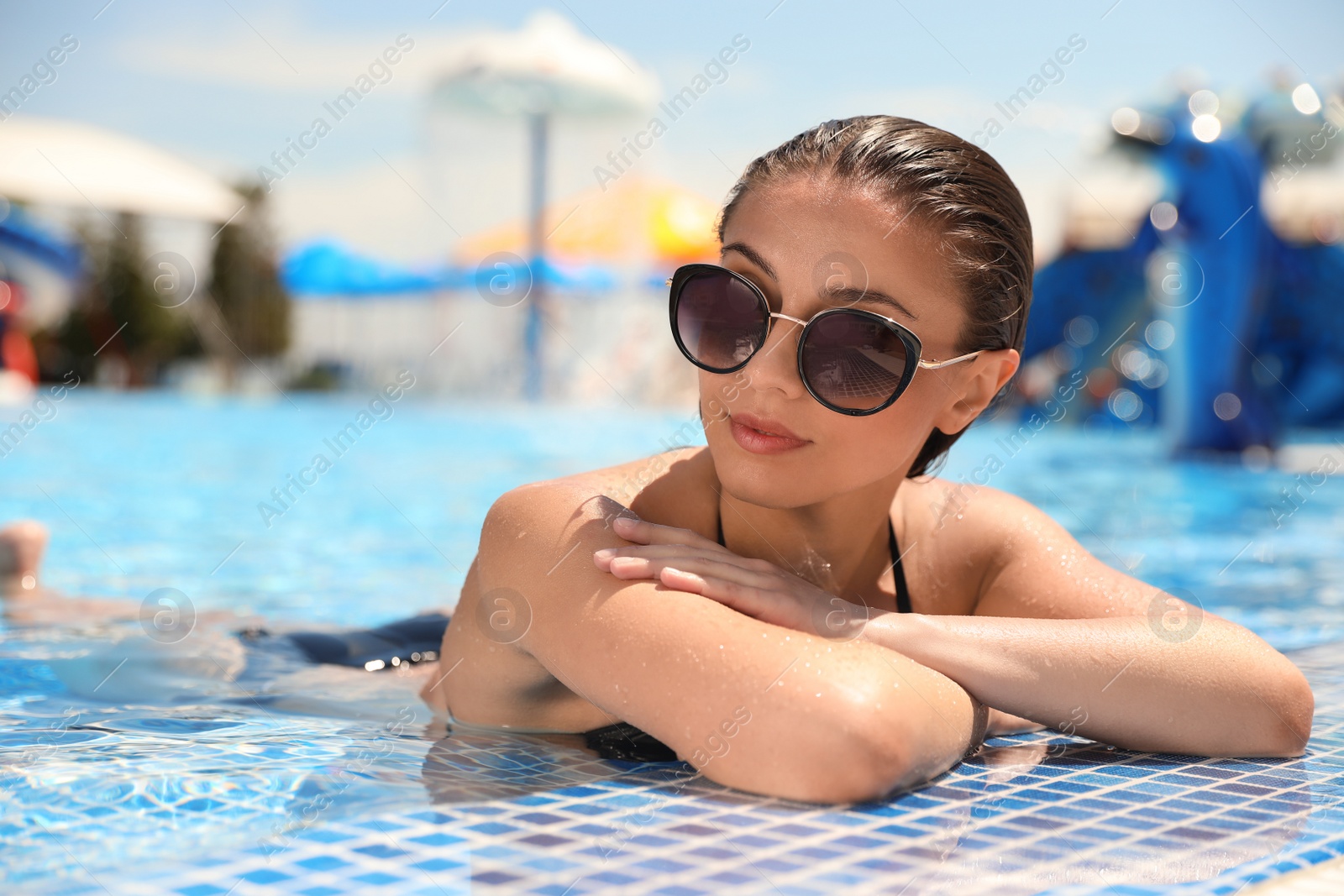 Photo of Young woman in outdoor swimming pool. Summer vacation