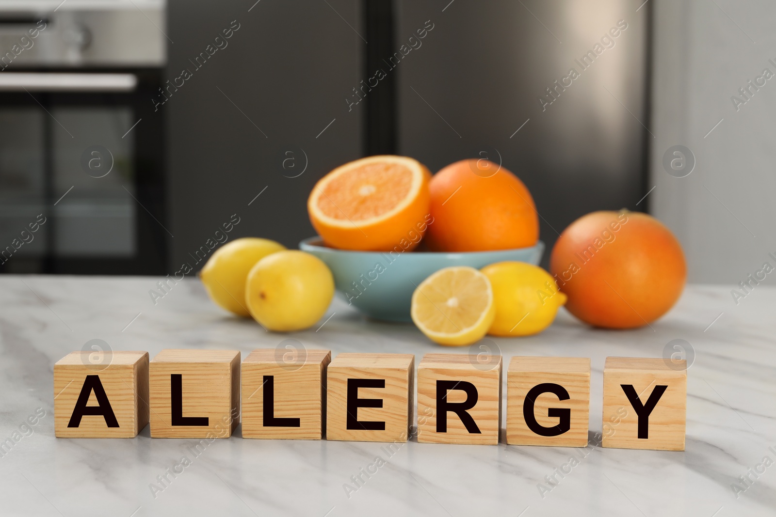 Image of Food allergy. Fresh citrus fruits and wooden cubes on white marble table