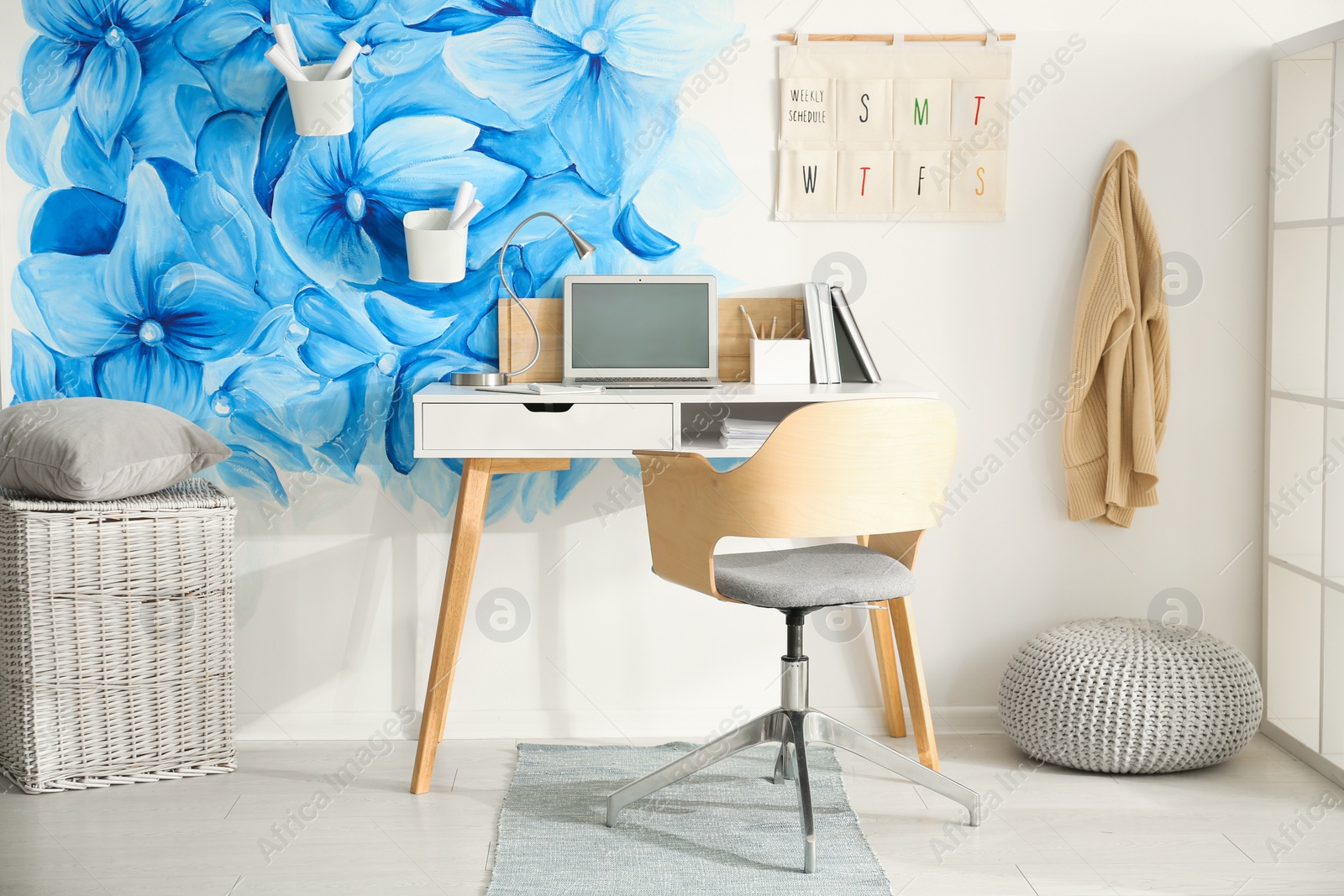 Photo of Stylish living room interior with blue flowers painted on wall. Floral pattern