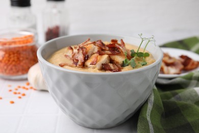 Photo of Delicious lentil soup with bacon and croutons on white table, closeup