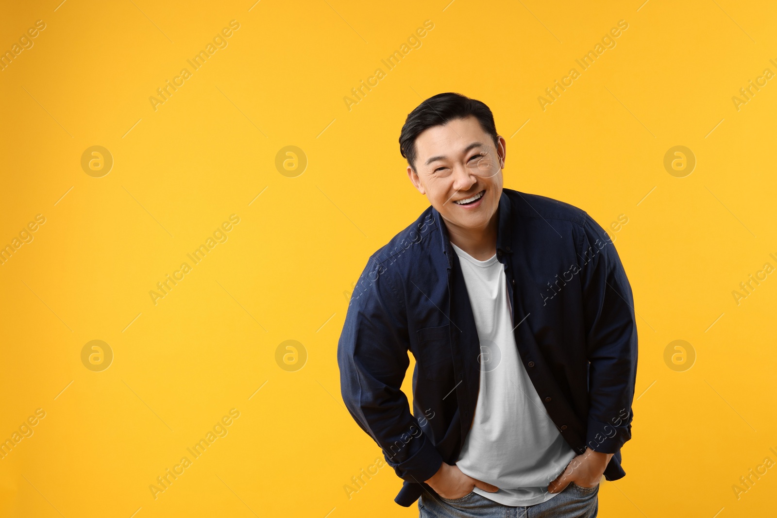 Photo of Portrait of happy man on yellow background. Space for text