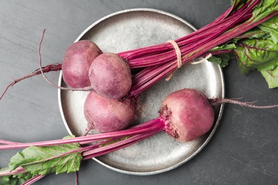 Raw ripe beets on black slate table, top view