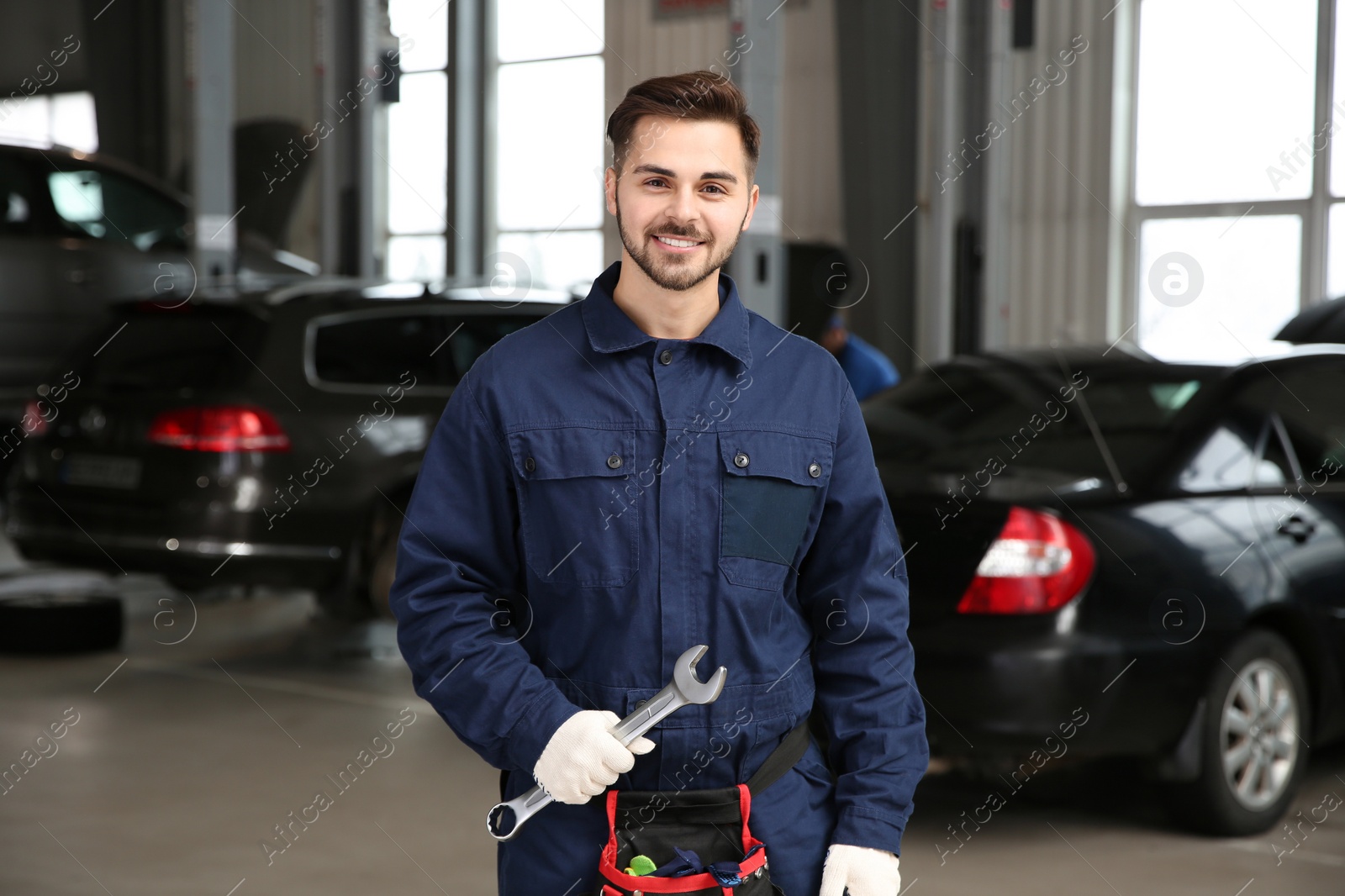 Photo of Portrait of technician with wrench at automobile repair shop