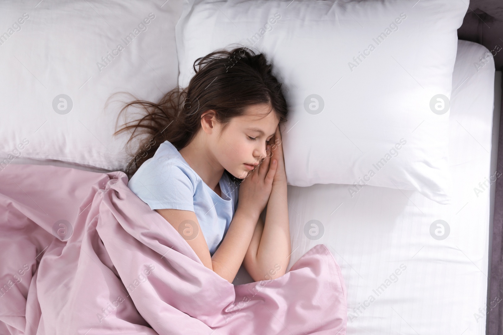Photo of Beautiful little girl sleeping in bed, top view