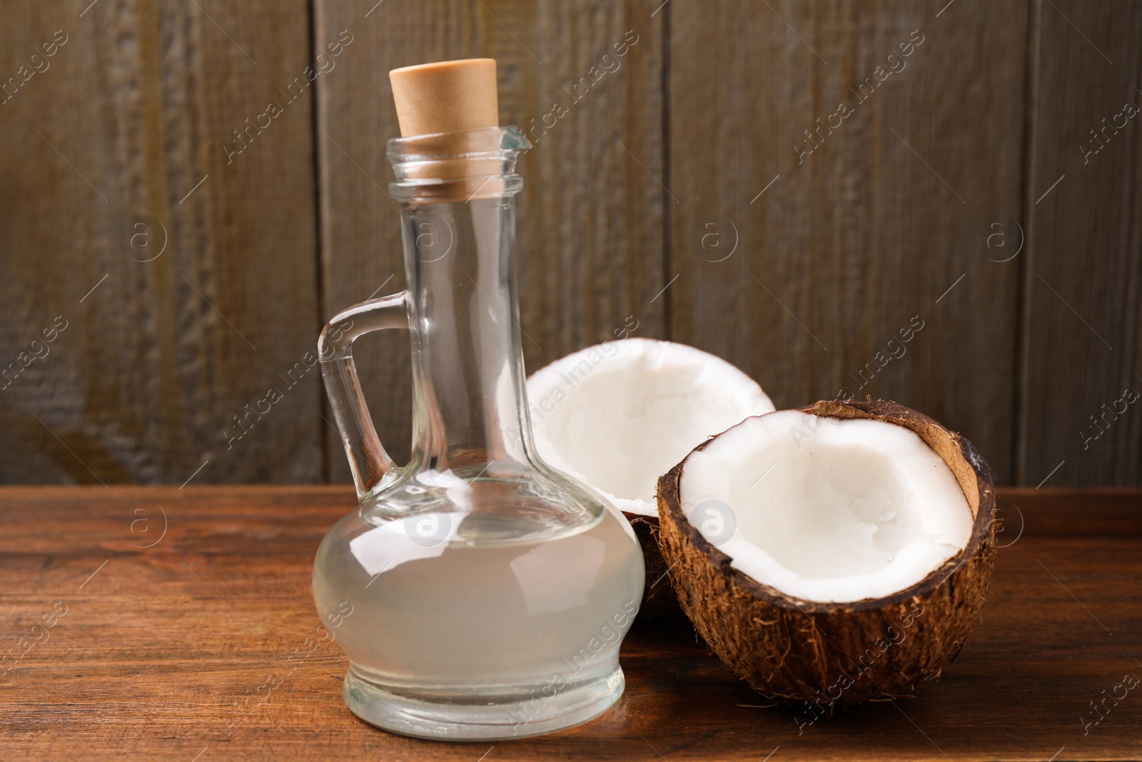 Photo of Coconut oil in glass jug on wooden table