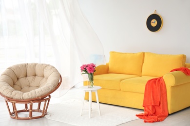 Elegant living room interior with comfortable sofa and papasan chair