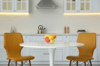 Photo of Table with orange chairs in modern kitchen interior