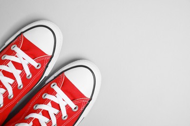Photo of Pair of new stylish red sneakers on light grey background, flat lay. Space for text