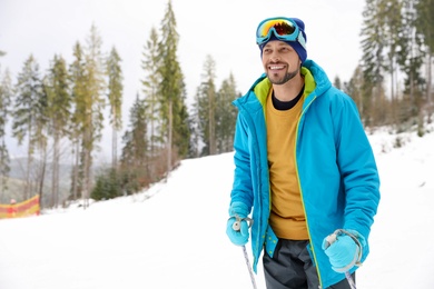 Photo of Male skier on slope at resort, space for text. Winter vacation