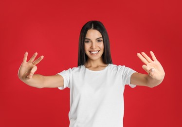 Photo of Woman showing number six with her hands on red background