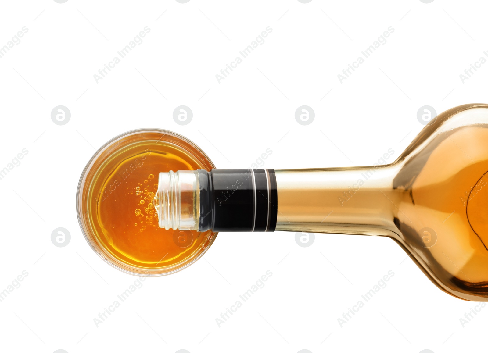 Photo of Pouring expensive whiskey into glass on white background, top view