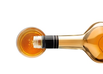 Photo of Pouring expensive whiskey into glass on white background, top view