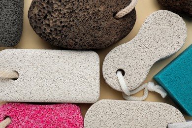 Different pumice stones on beige background, flat lay