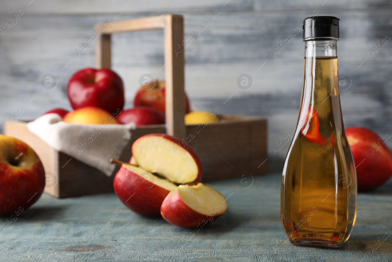 Photo of Composition with bottle of apple vinegar on table. Space for text