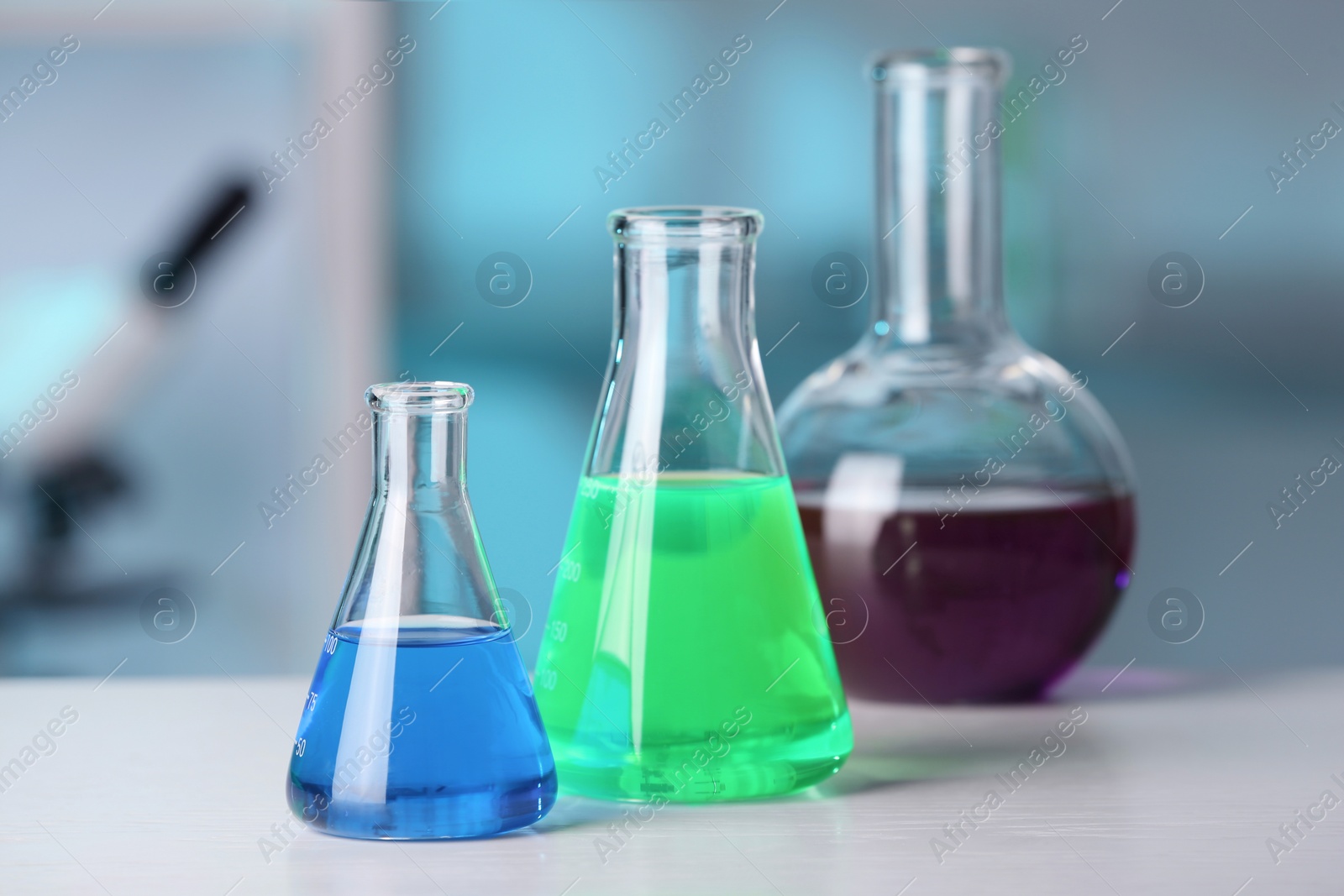 Photo of Laboratory glassware with samples on table indoors. Solution chemistry