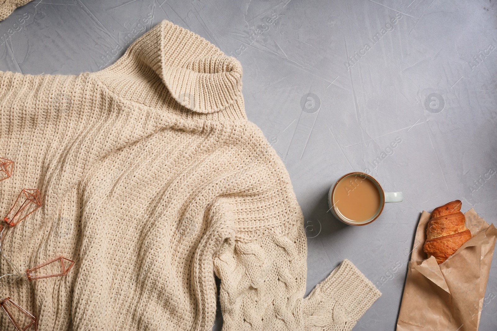 Photo of Flat lay composition with warm sweater on gray background