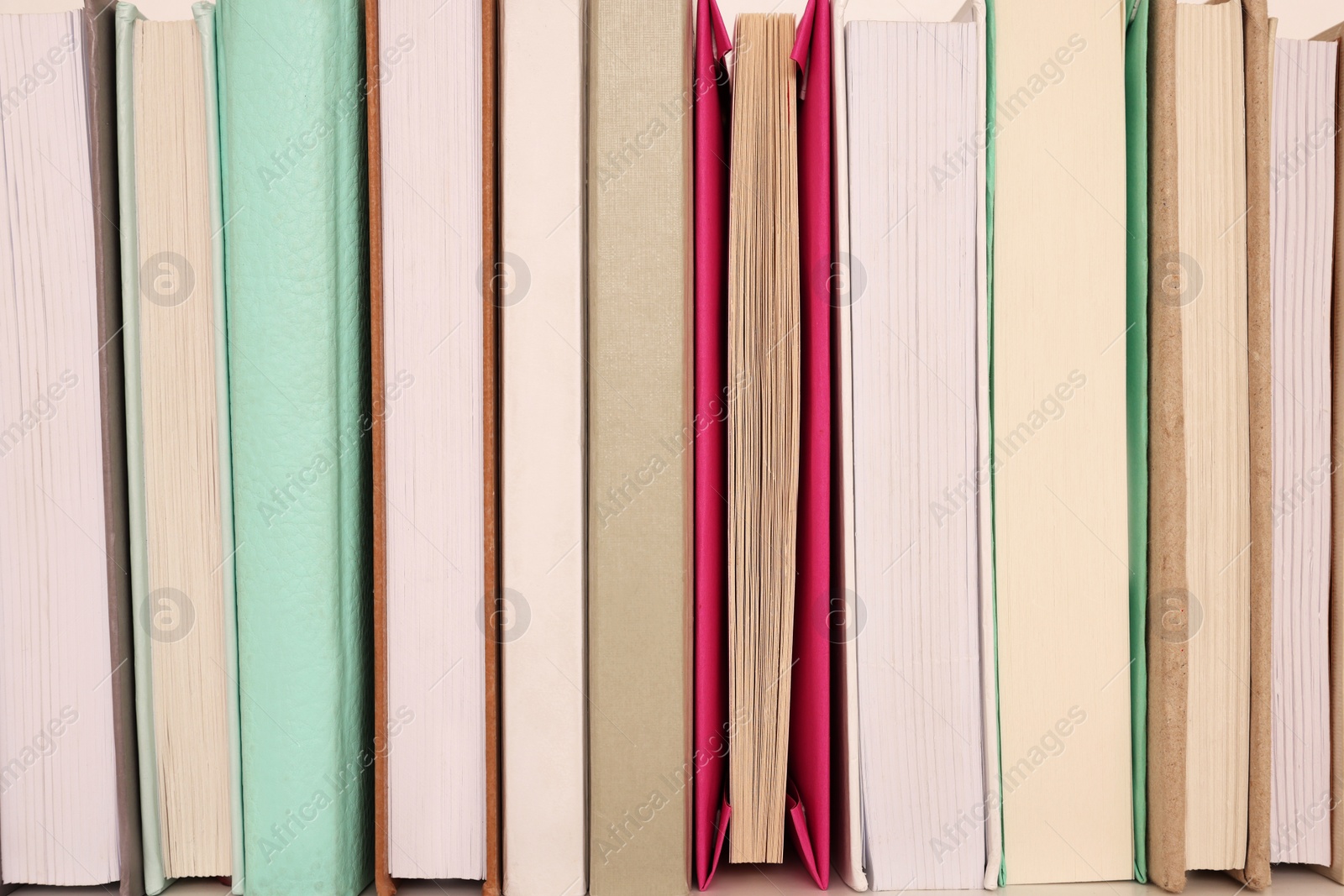 Photo of Many different hardcover books on shelf, closeup