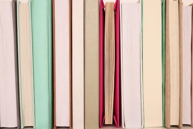 Photo of Many different hardcover books on shelf, closeup