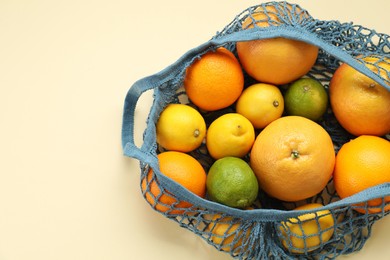 String bag with different fruits on beige background, top view. Space for text