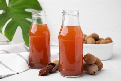 Photo of Tamarind juice and fresh fruits on white table