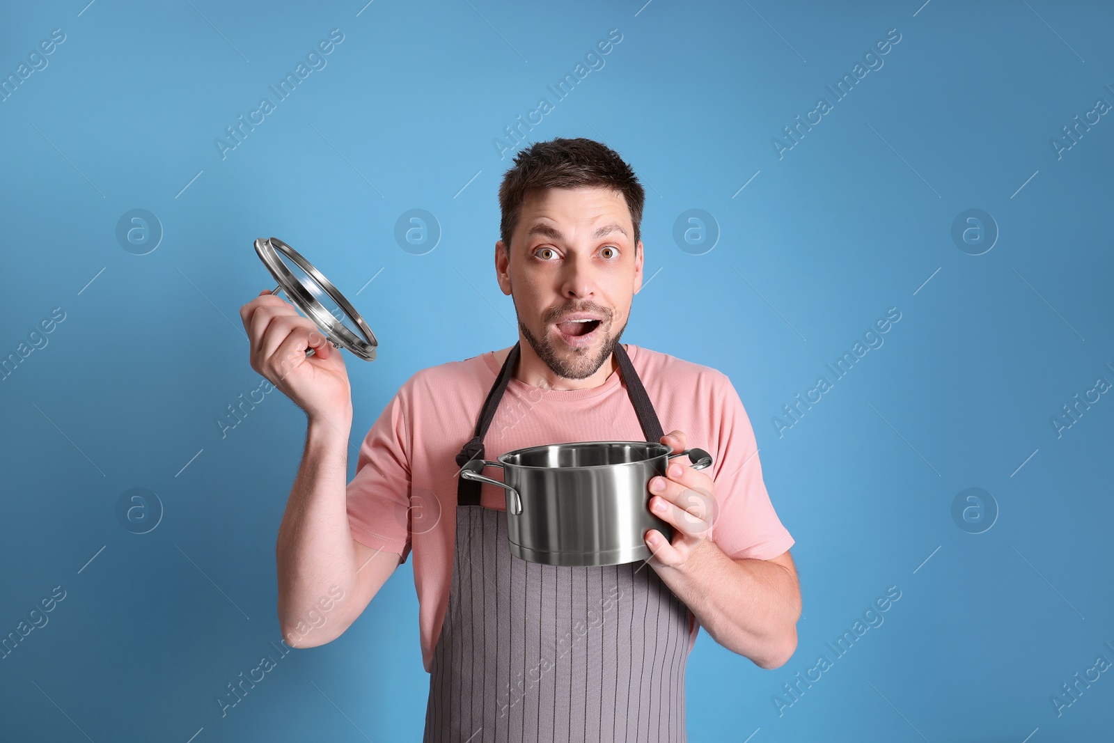 Photo of Surprised man with pot on light blue background