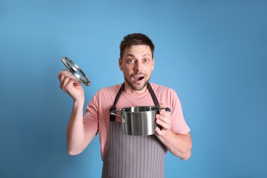 Surprised man with pot on light blue background