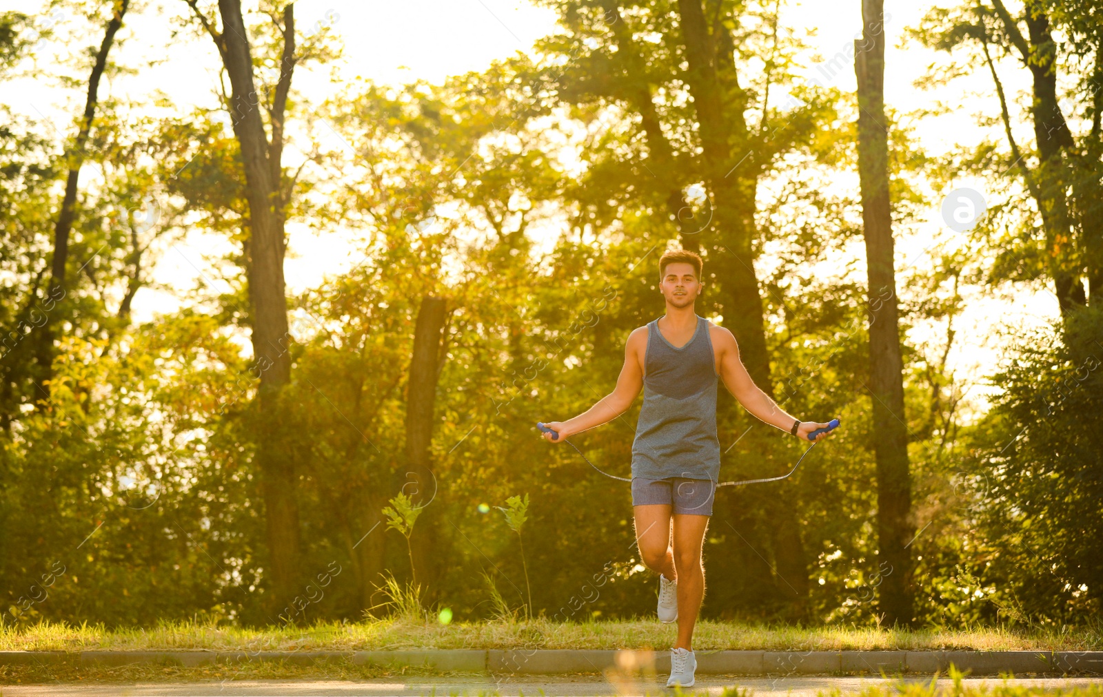 Photo of Young man training with jump rope in park