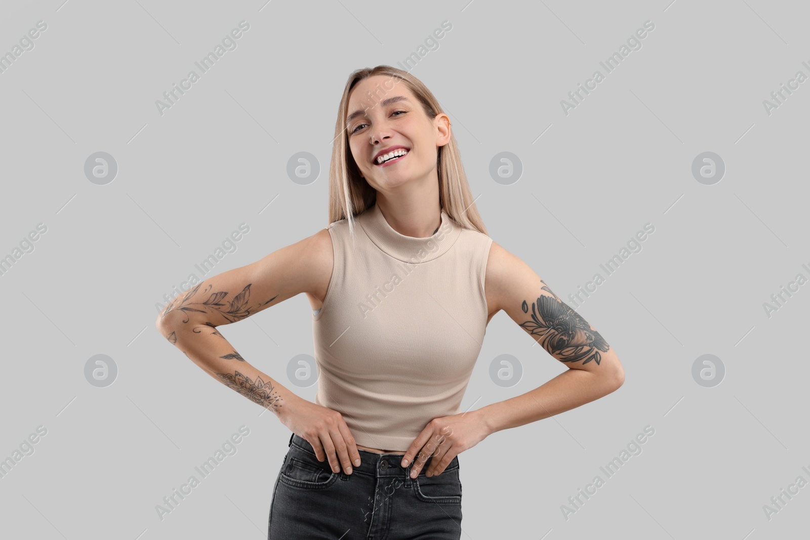 Photo of Portrait of beautiful tattooed woman on gray background