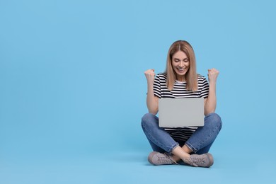 Emotional woman with laptop on light blue background. Space for text