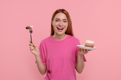 Photo of Young woman with piece of tasty cake on pink background