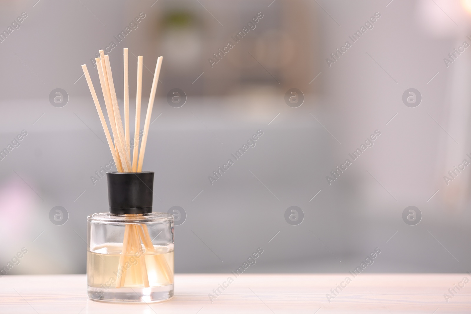 Photo of Handmade reed freshener on table against blurred background