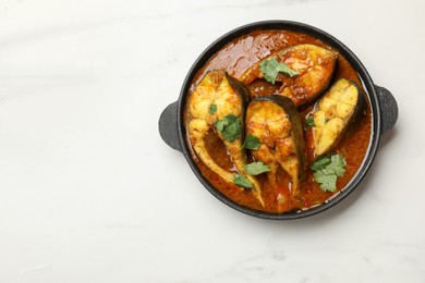 Photo of Tasty fish curry on white marble table, top view. Space for text. Indian cuisine