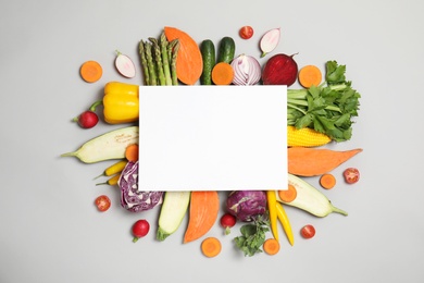 Photo of Flat lay composition with fresh vegetables and blank card for text on gray background