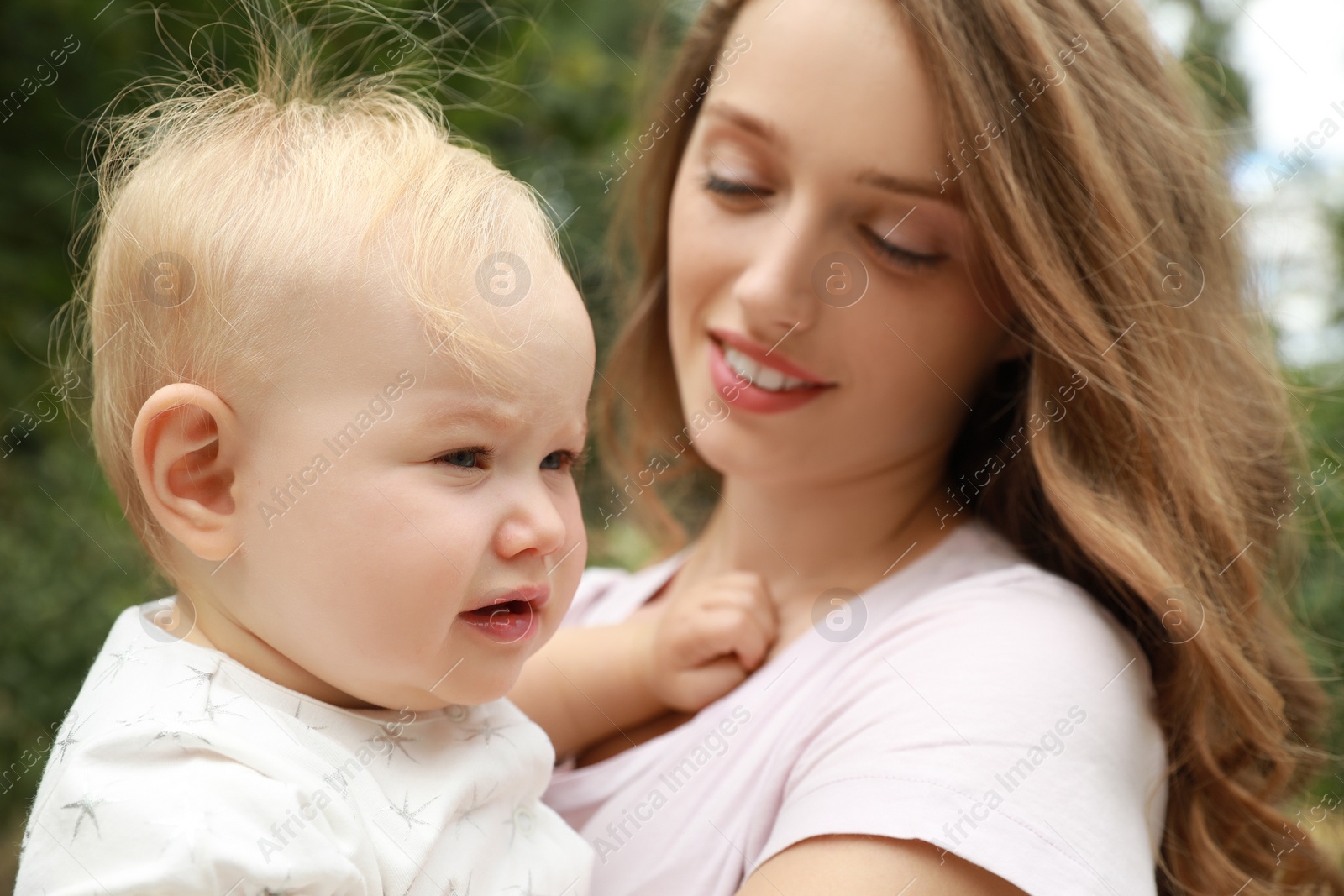 Photo of Mother with her cute baby spending time together outdoors, selective focus