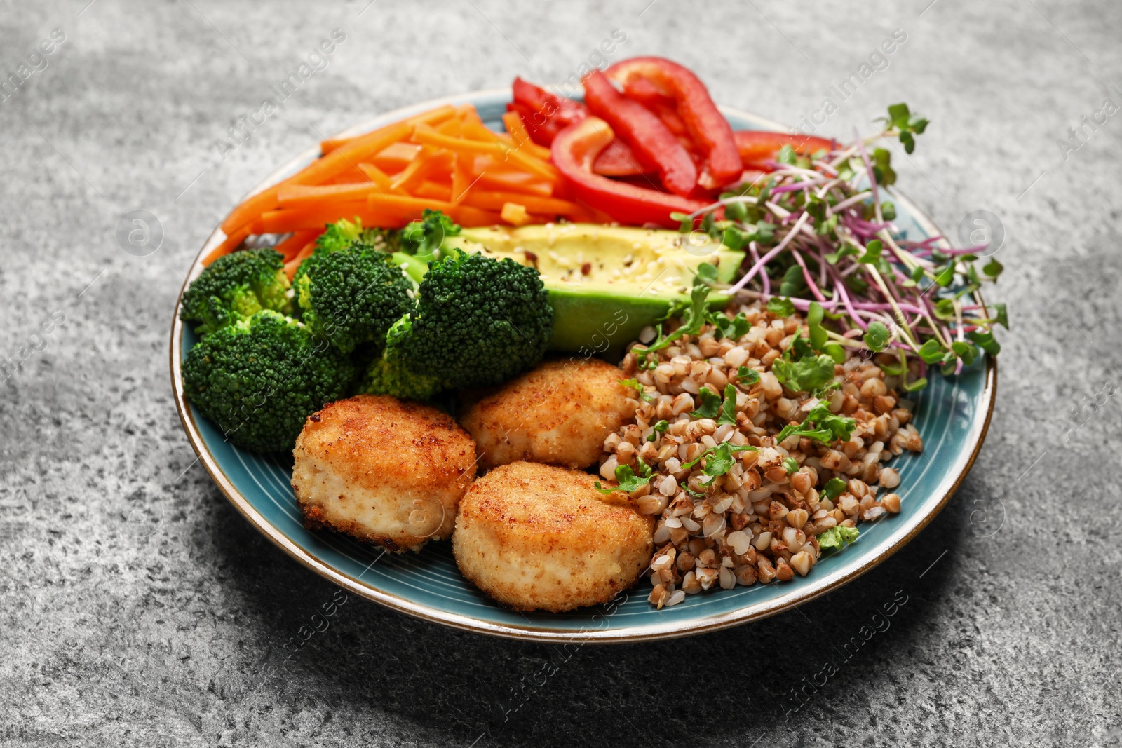 Photo of Delicious vegan bowl with cutlets, buckwheat and broccoli on grey table, closeup