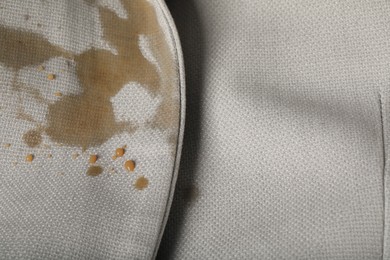 Dirty jacket with stain of coffee as background, closeup