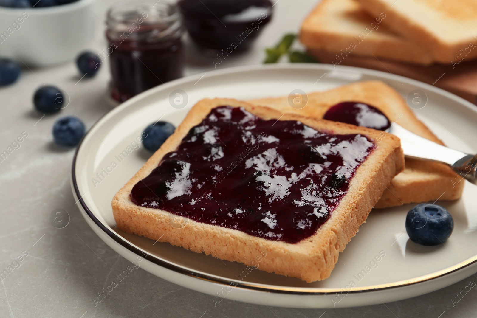 Photo of Toast with blueberry jam served on table, closeup