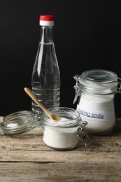 Photo of Baking soda, spoon and vinegar on wooden table
