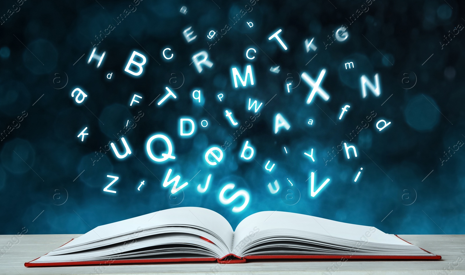 Image of Letters flying out from open book on table, bokeh effect. Banner design