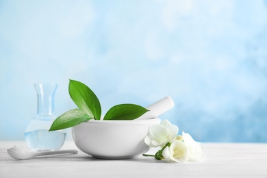 Composition with mortar and pestle on table against color background. Homemade cosmetic products