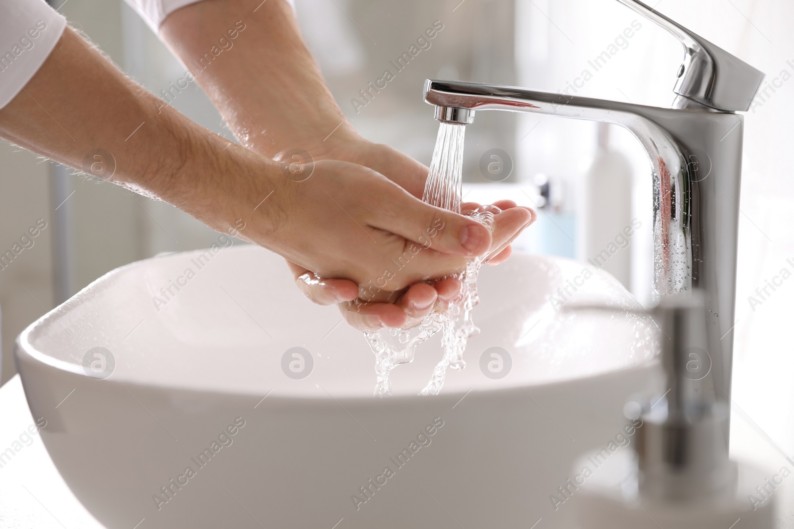 Photo of Man washing hands over sink in bathroom, closeup