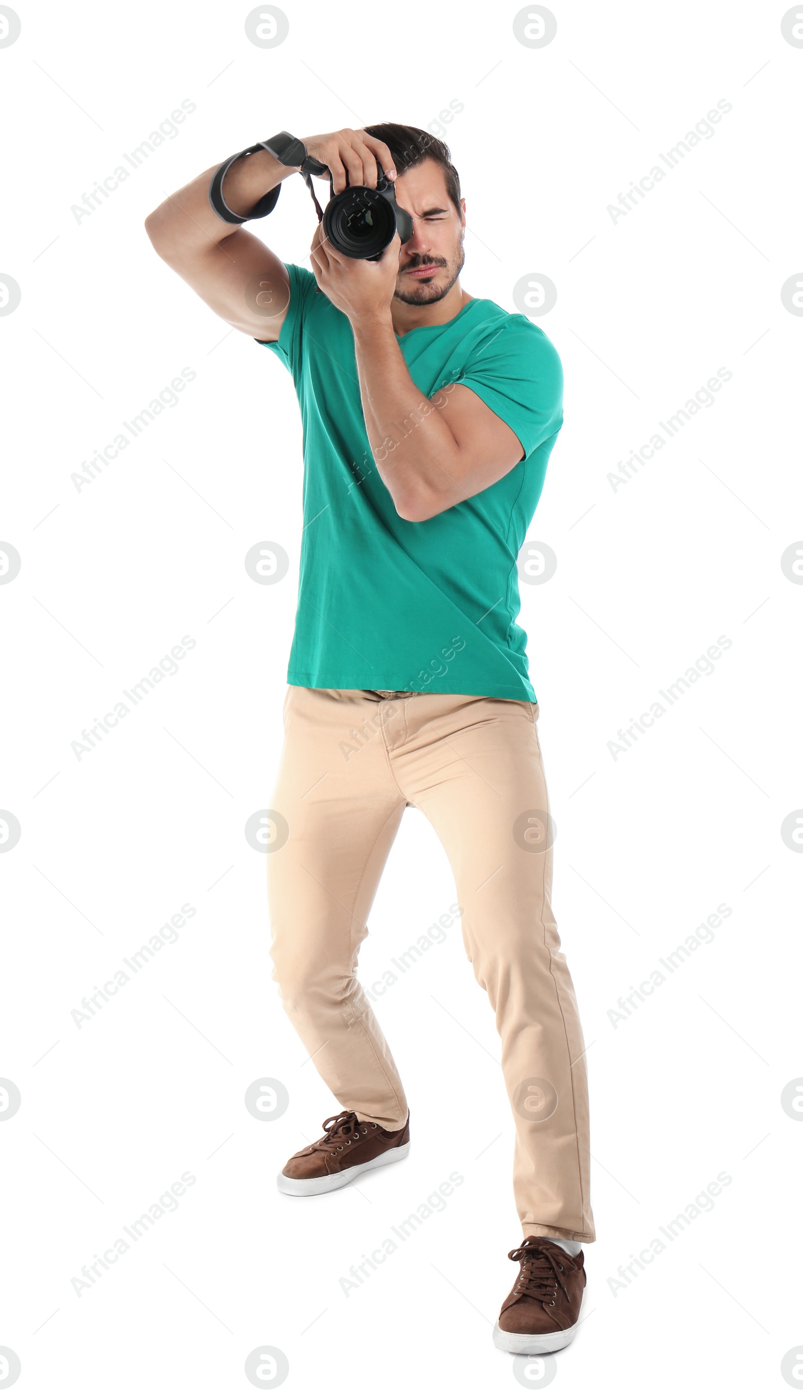 Photo of Young professional photographer taking picture on white background