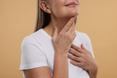 Photo of Mature woman with healthy skin on beige background, closeup