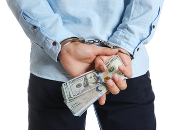 Photo of Man in handcuffs holding bribe money on white background, closeup