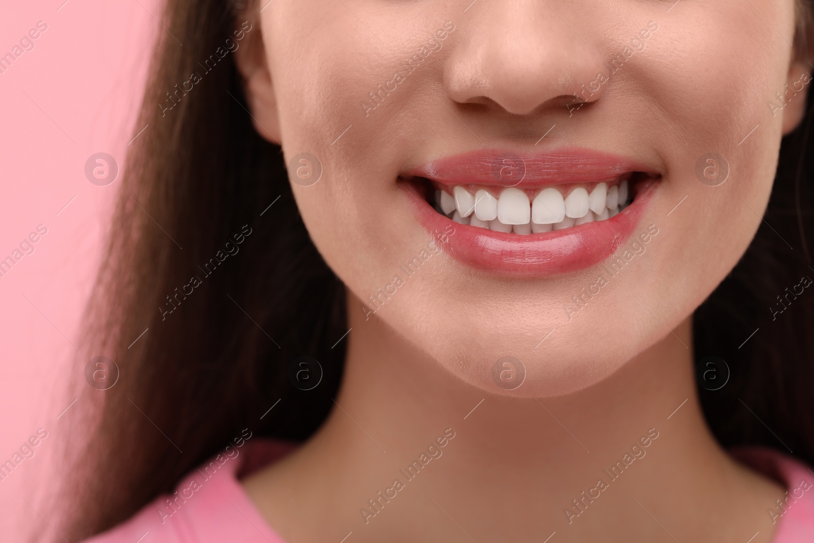 Photo of Woman with clean teeth smiling on pink background, closeup