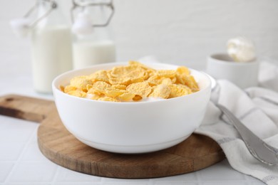 Photo of Breakfast cereal. Tasty corn flakes with milk in bowl on white table