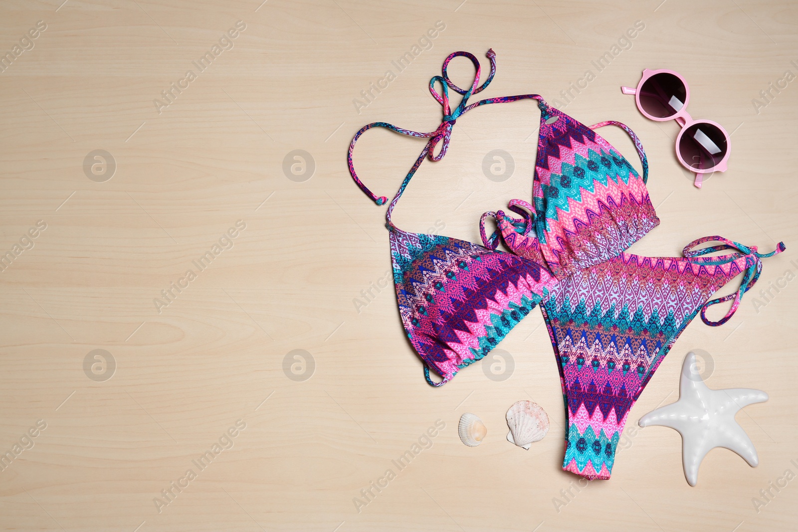 Photo of Flat lay composition with stylish bikini on wooden background. Space for text