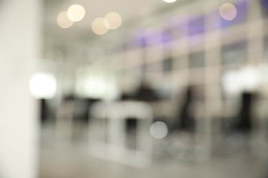 Photo of Blurred view of cozy workspaces with tables and chairs in office