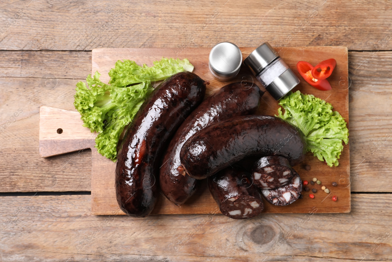 Photo of Tasty blood sausages served on wooden table, top view